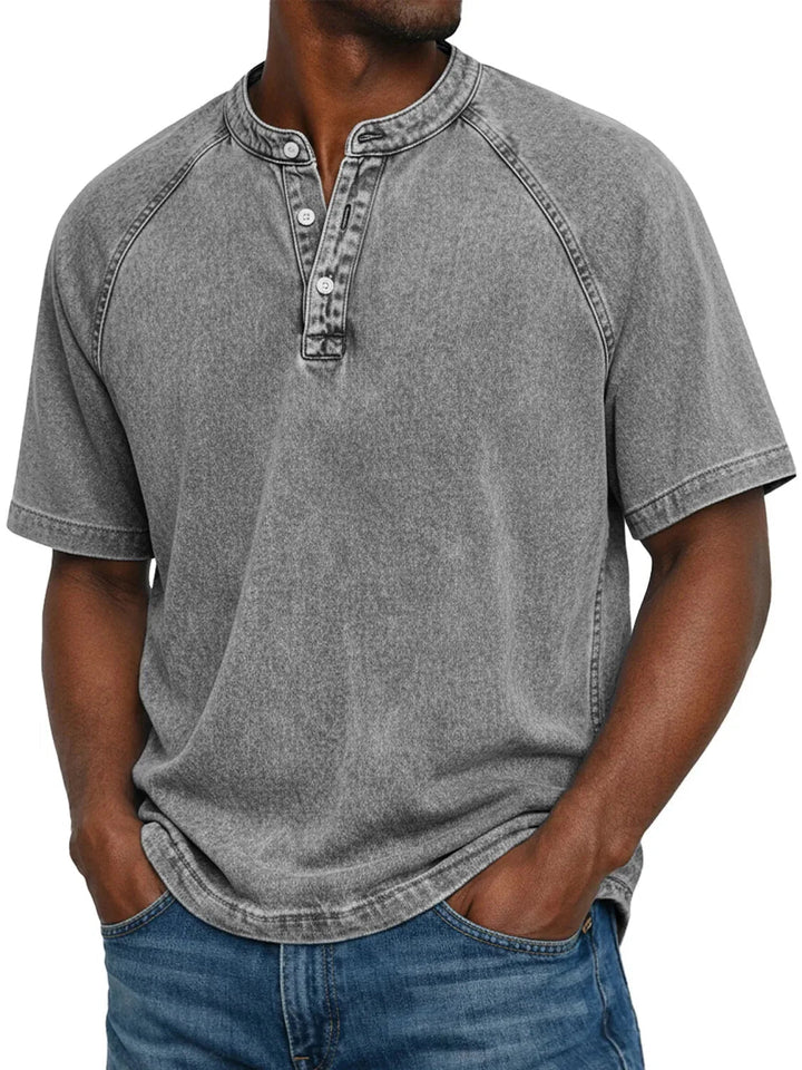 T-shirt Henley homme casual avec un jean. Manches courtes, col boutonné, style moderne pour l'été.