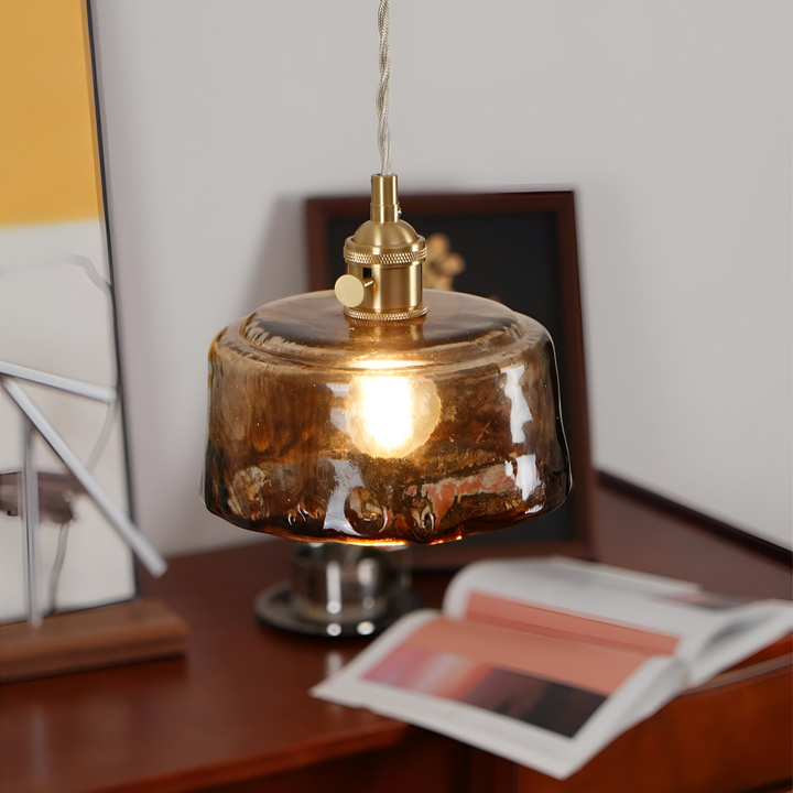 Suspension vintage en verre ambré et laiton, touche rétro chic pour la salle à manger.
