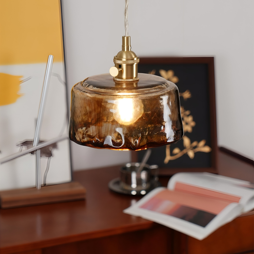 Suspension élégante laiton et verre, apporte une lumière douce au salon.