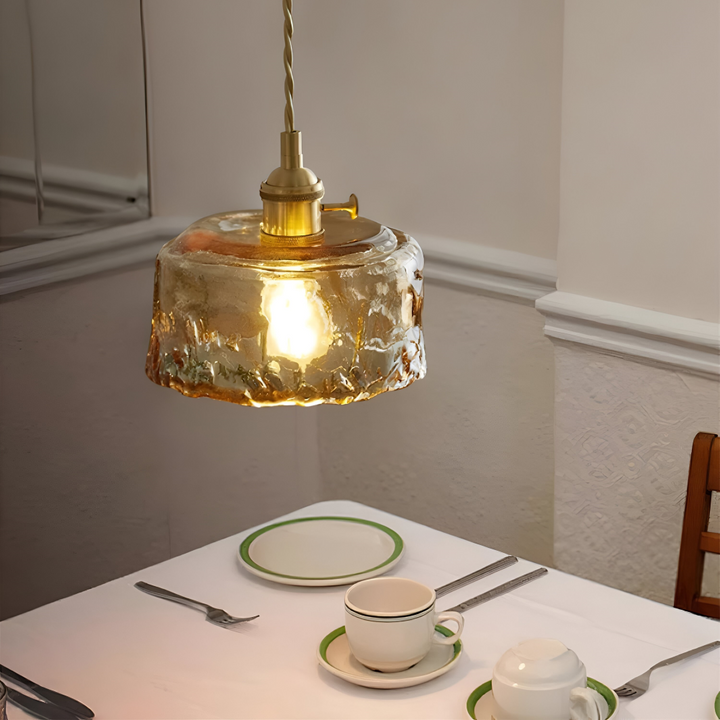 Luminaire rétro en verre ambré et laiton antique pour salle à manger élégante.