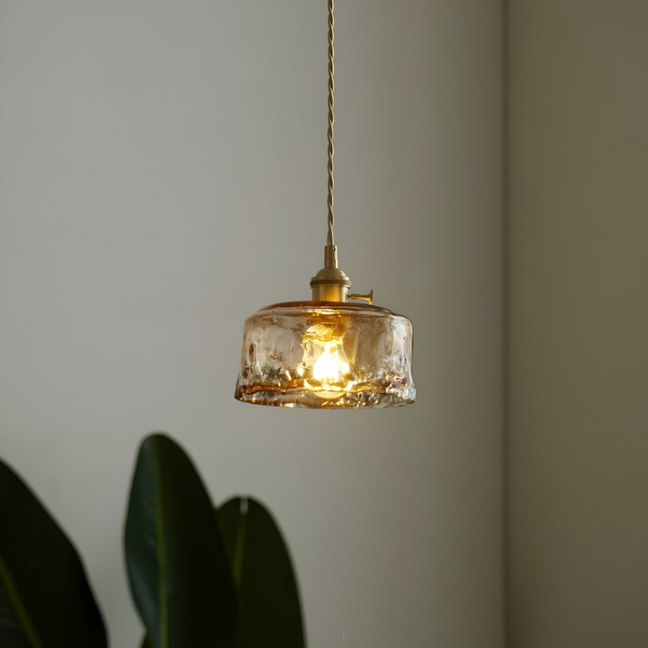 Plafonnier vintage en verre et laiton, pièce maîtresse de la décoration.