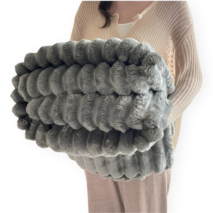Accessoire essentiel: couverture polaire ultra-douce pour des moments de détente confortables sur le canapé.
