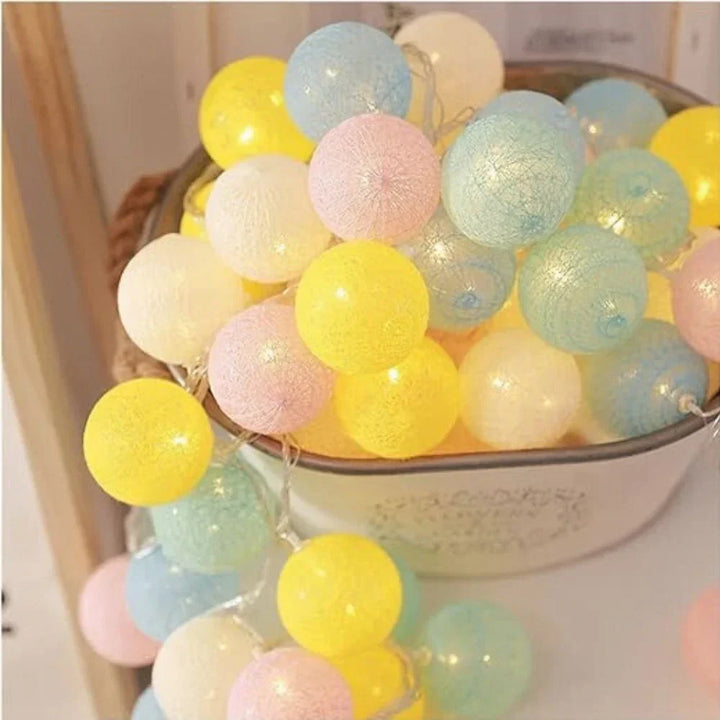Lumière d'accentuation : guirlande lumineuse LED boules de coton sur une commode.