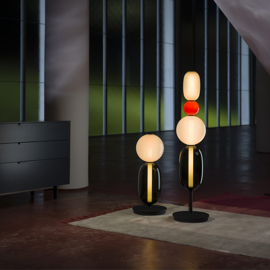 Luminaire artistique sur pied, diffuse une lumière chaleureuse avec son verre teinté.