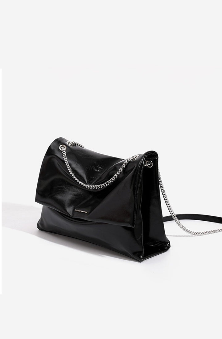 Détail du sac à main femme: rabat texturé, bandoulière chaîne chic, pour une touche d'élégance.