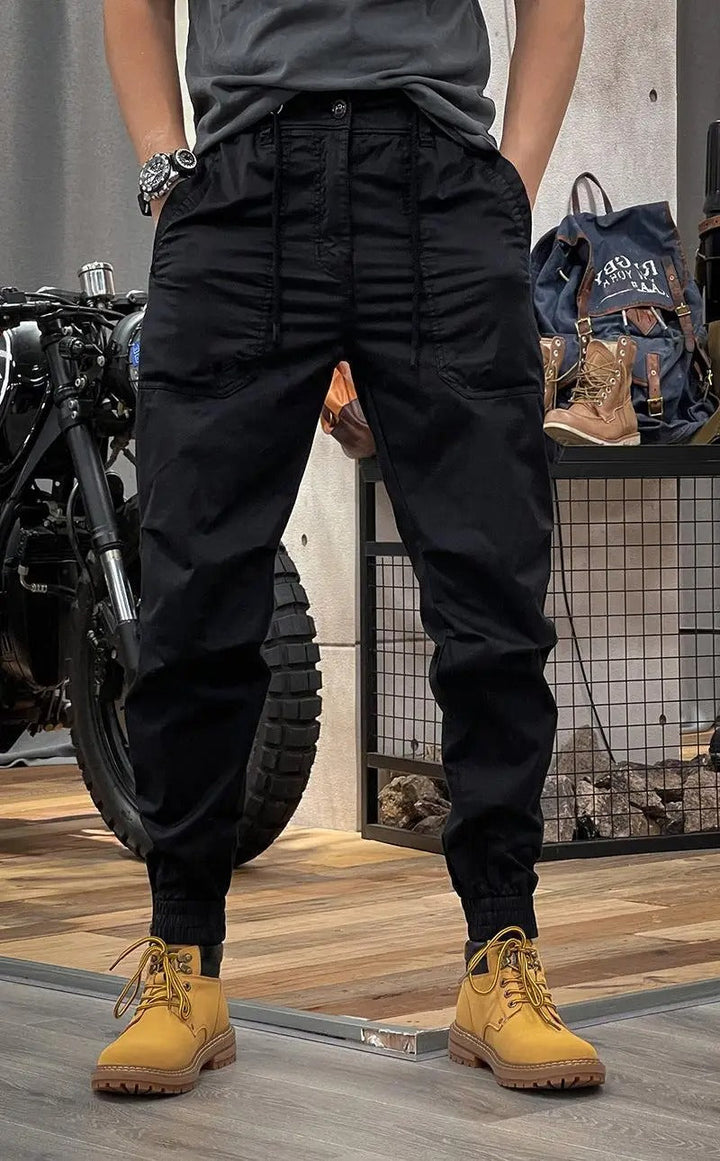 Homme portant un pantalon cargo slim noir, vue de face. Confort stretch et look casual-chic. Idéal pour le quotidien.
