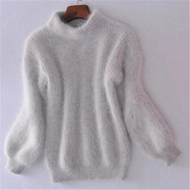 Gros plan sur le pull femme en tricot, avec col montant raffiné et manches bouffantes tendance pour mode hiver.