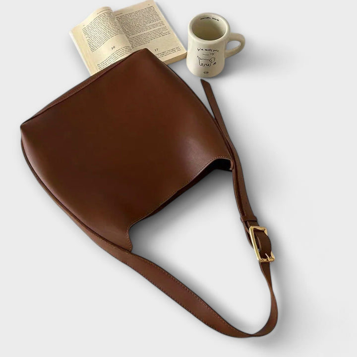 Détail du fermoir doré sur sac à bandoulière en cuir PU noir, un sac à main femme moderne et chic.