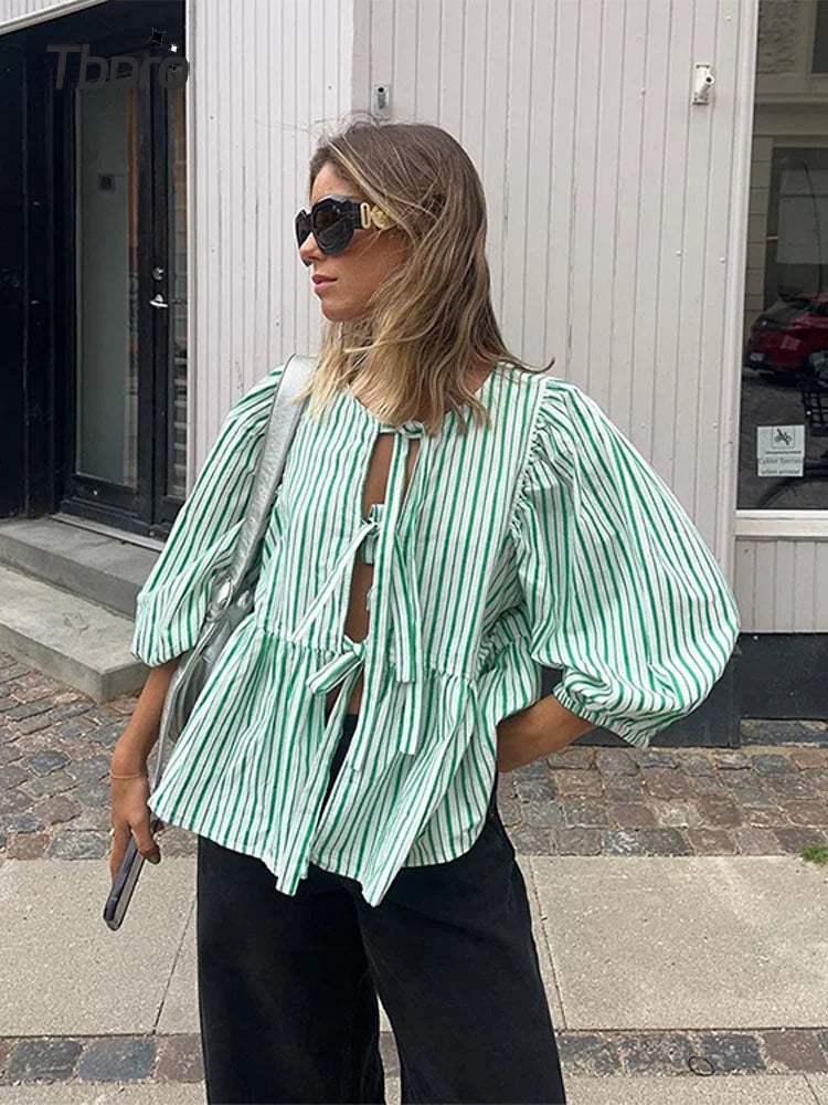 Haut femme rayé élégant, manches bouffantes, col rond. Chic et confortable pour toute occasion.
