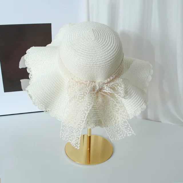 Élégant chapeau de paille femme avec bord large et raffinée dentelle florale. Accessoire mode estival.