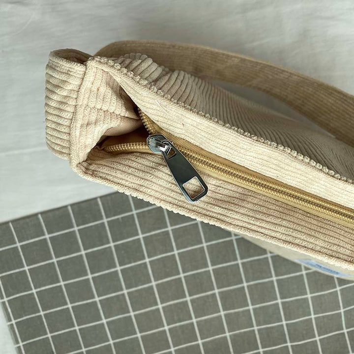 Sac à main décontracté en velours côtelé vert, style urbain et pratique, avec bandoulière ajustable.