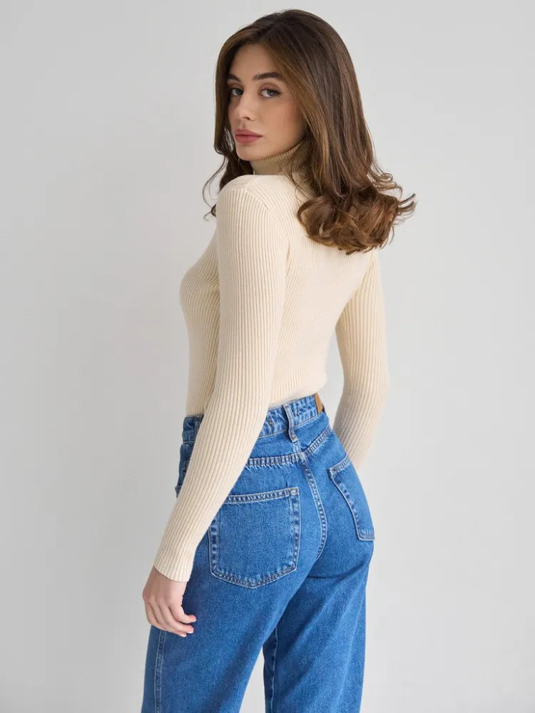 Pull femme en tricot à col roulé, coupe ajustée, idéal pour un look sophistiqué en automne-hiver.