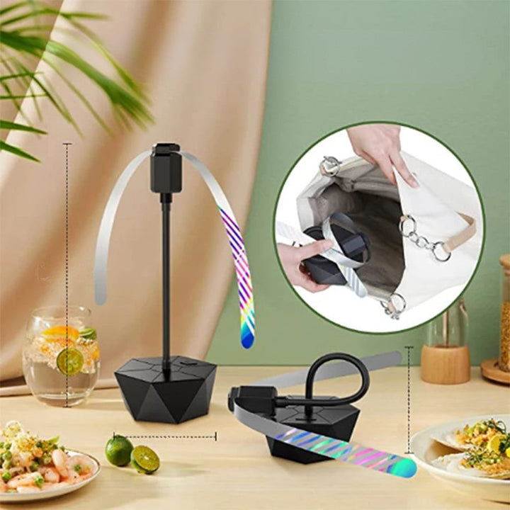Ventilateur portable anti-mouche sur une table de terrasse, idéal pour repas extérieurs et barbecues sans insectes.