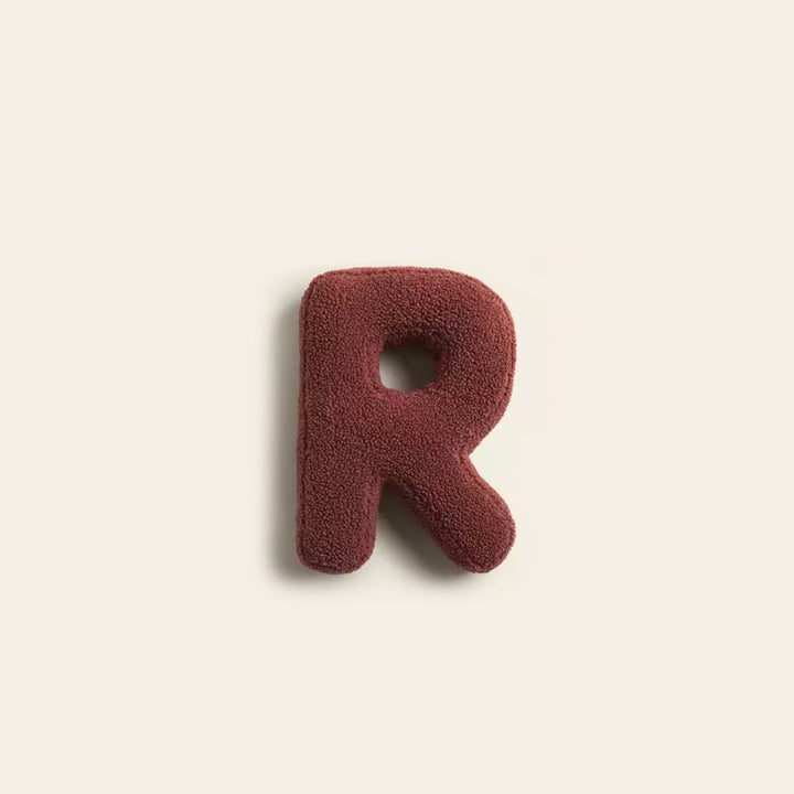 Coussin moderne lettre R, décoratif et confortable pour un espace.
