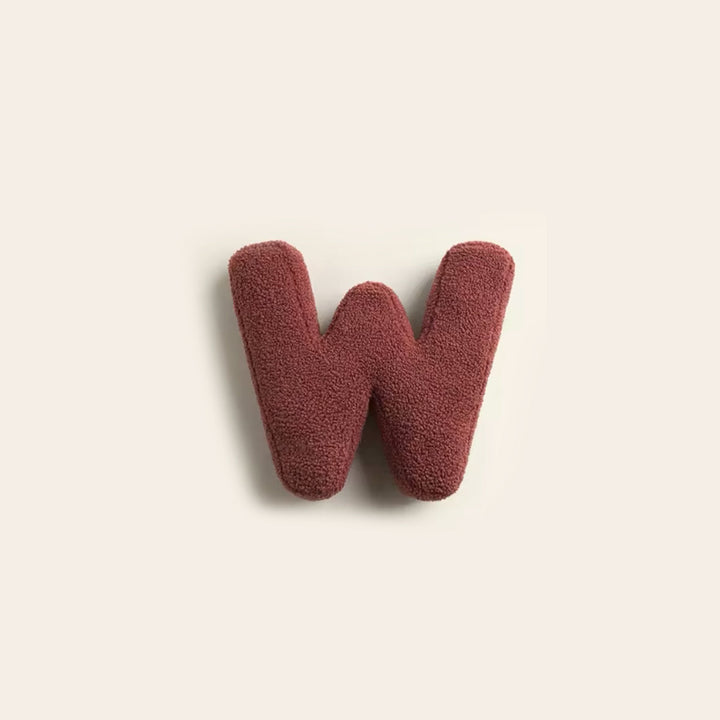 Coussin alphabet design V, parfait pour un intérieur contemporain.