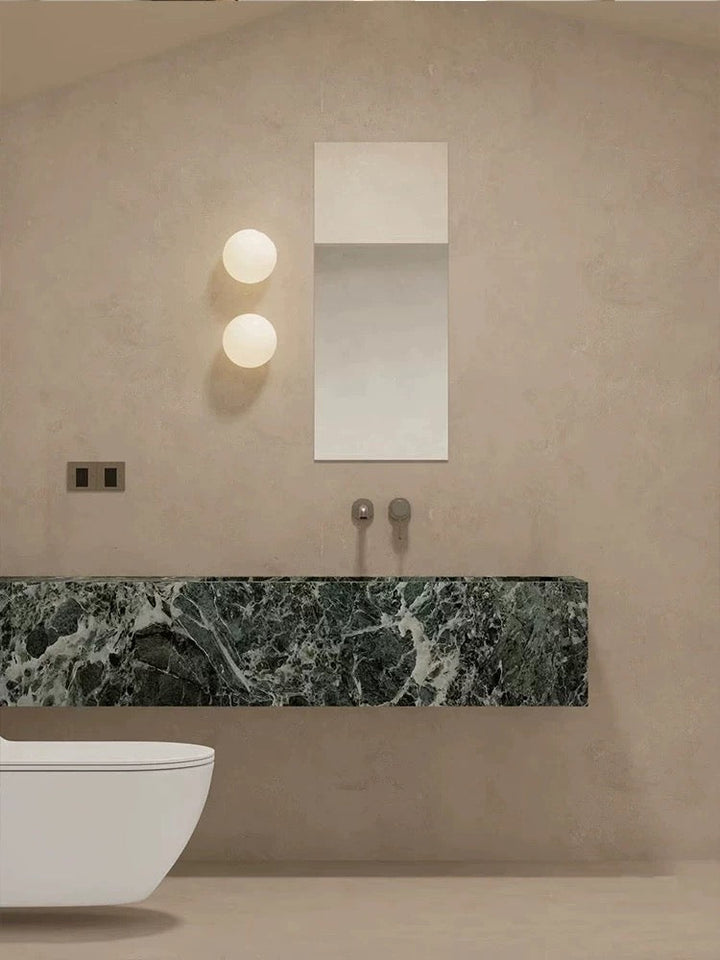 Applique murale design minimaliste, boule en verre opale. Crée une ambiance chaleureuse avec sa lumière douce.