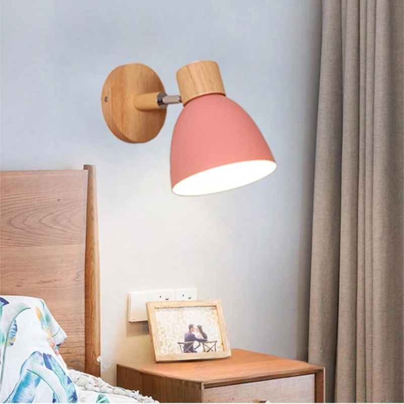 Gros plan sur l'applique murale scandinave : abat-jour en fer noir et bras articulé en bois massif.