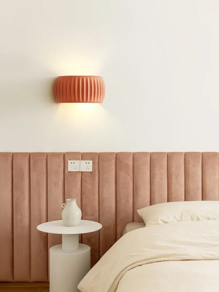Éclairage mural design en résine texturée blanc chaud, diffuse une lumière douce et ambiante moderne.