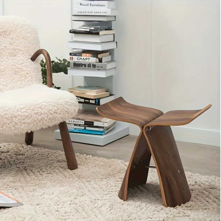 Tabouret Papillon intemporel bois foncé, touche de design et confort pour un coin lecture.