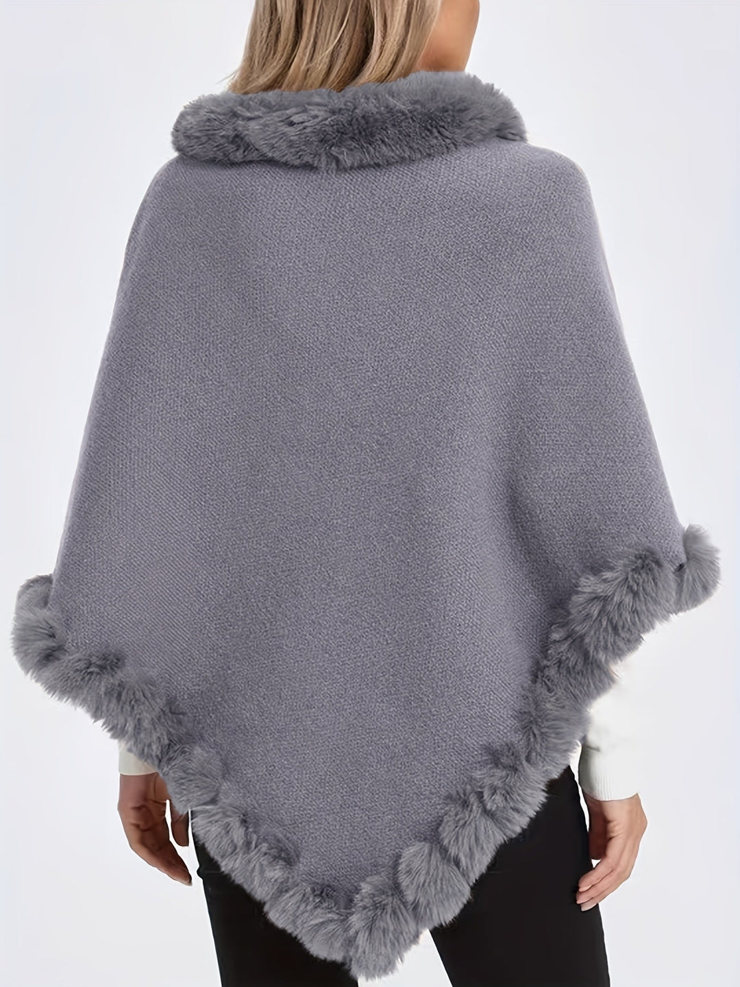 Femme portant un pull cape col roulé, fausse fourrure élégante, tricot épais pour l'hiver froid.