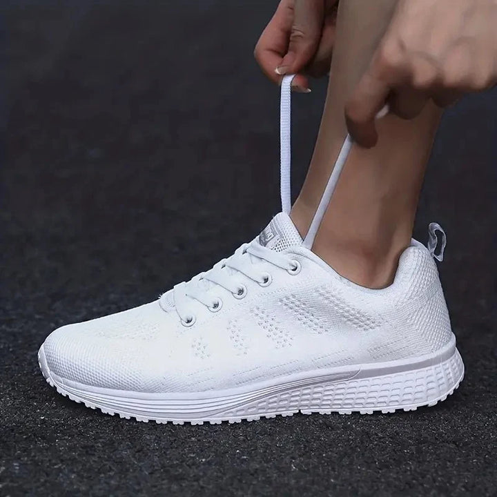 Paire de baskets femme blanches en maille, ultra légères et respirantes, offrant un soutien confortable au quotidien.