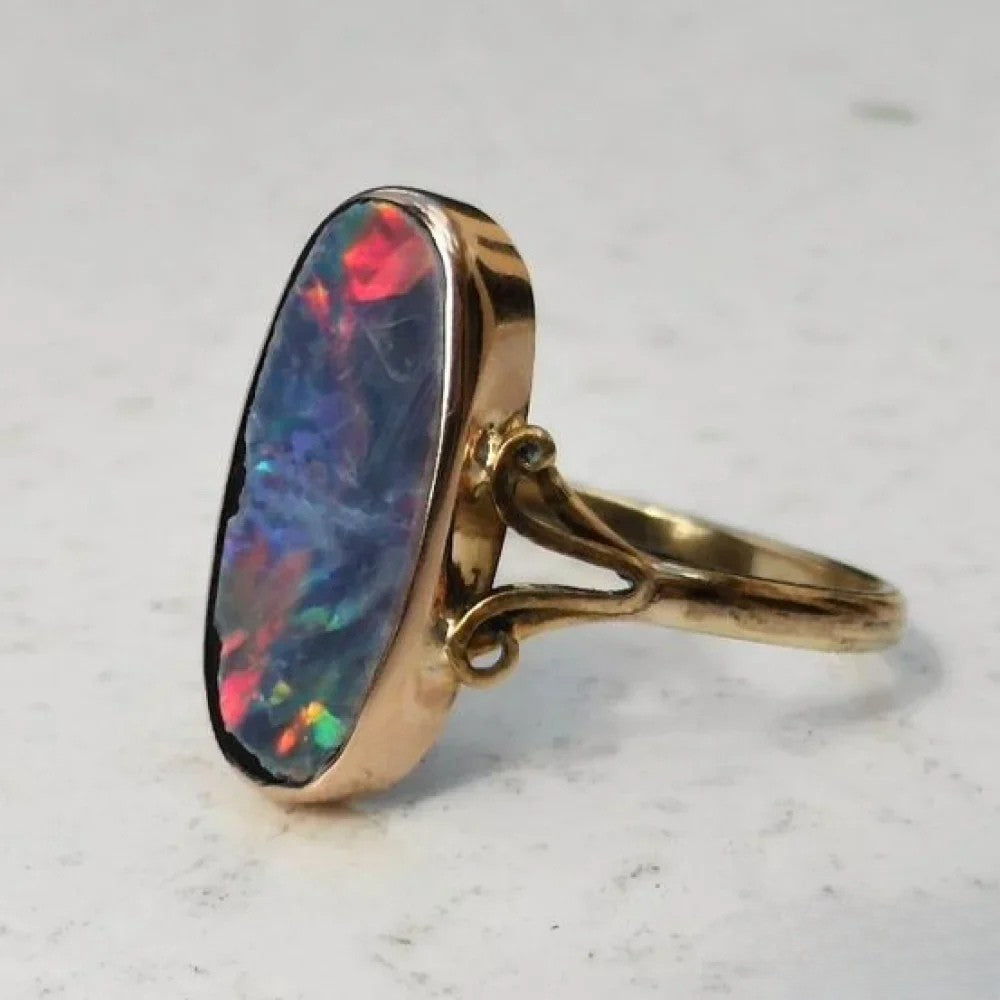 Bague rétro femme avec opale multicolore ovale, bijou vintage élégant, pierre précieuse étincelante.