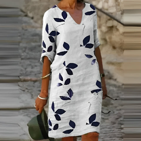 Robe fluide d'été tendance pour femme avec imprimé feuilles blanc, vert et marron. Idéale pour un look féminin estival.