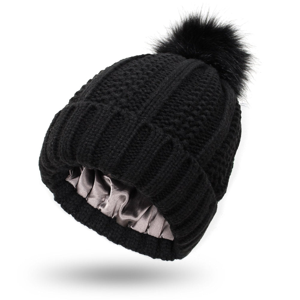 Bonnet tricoté femme à pompon, style hiver élégant. Doublure satinée pour chaleur et confort.