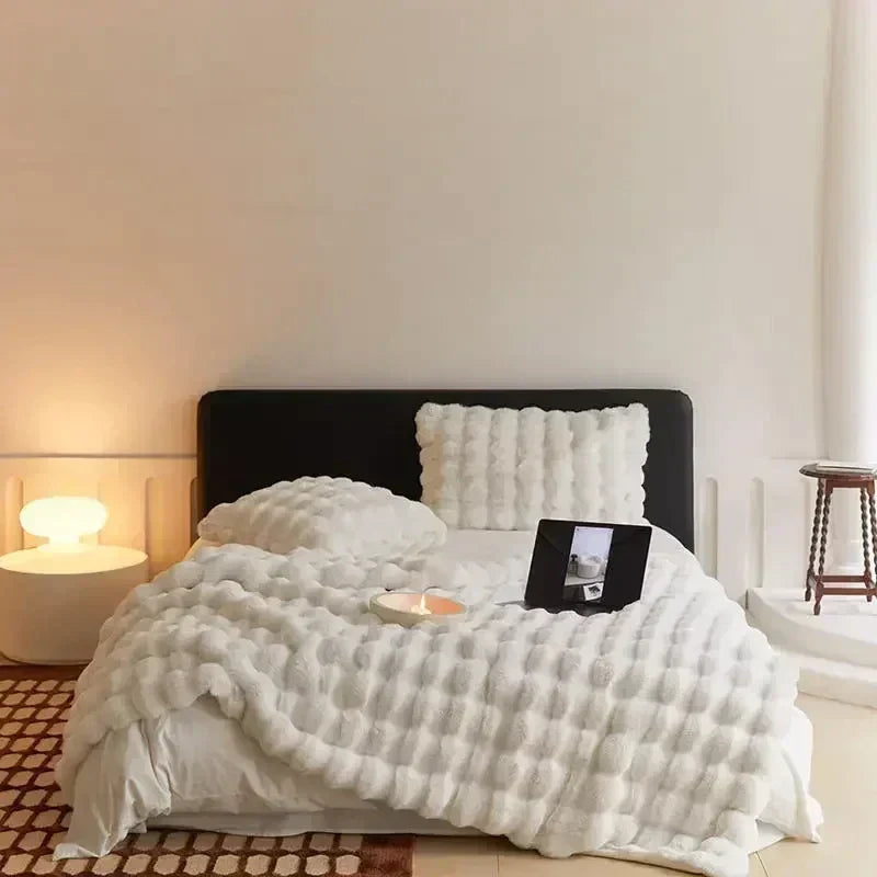 Plaid confort en fausse fourrure beige, ultra doux et chaud. Idéal pour les soirées cosy dans la chambre.