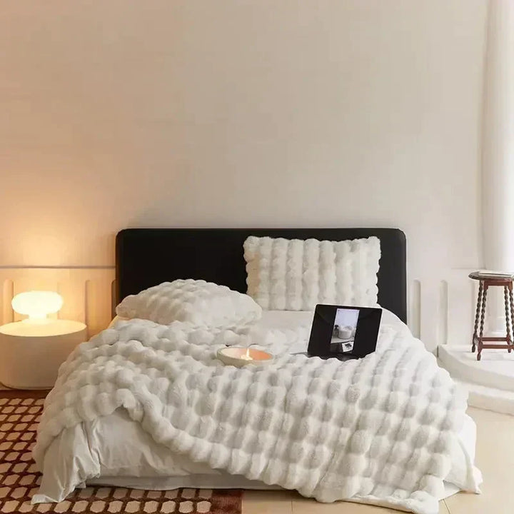 Plaid confort en fausse fourrure beige, ultra doux et chaud. Idéal pour les soirées cosy dans la chambre.