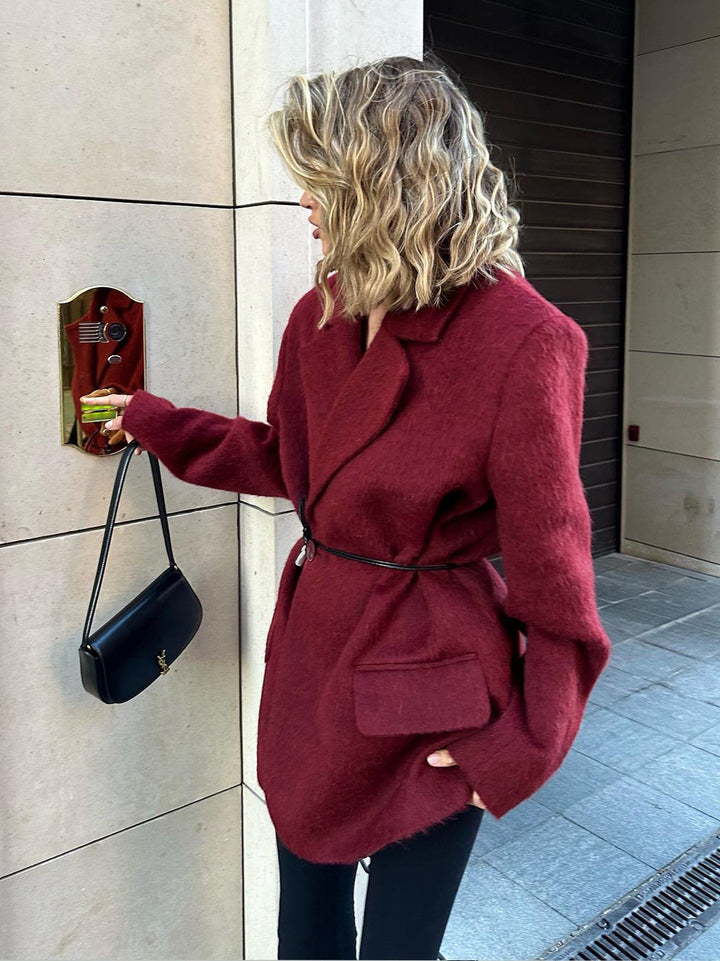 Veste femme chic rouge, coupe ajustée avec ceinture fine, idéale pour un style sophistiqué au bureau ou une occasion spéciale.