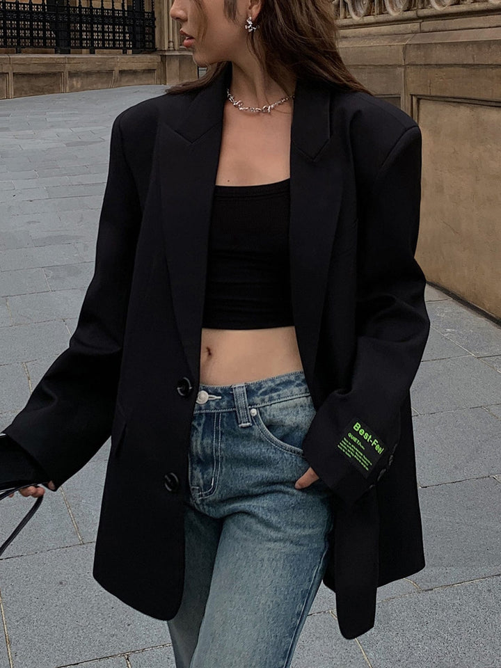 Blazer femme oversize gris, porté ouvert. Style décontracté chic et moderne, parfait pour le printemps/automne.