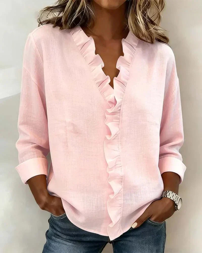 Blouse femme élégante à volants blancs, col V et manches longues. Parfaite pour le bureau ou une sortie décontractée.
