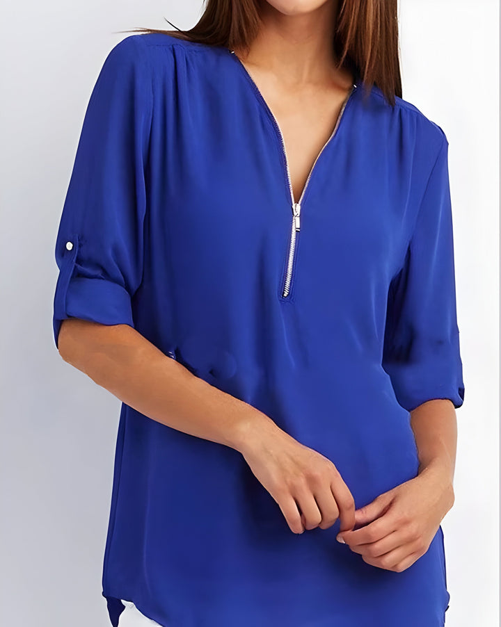 Blouse femme zippée chic, portée avec une jupe crayon, look élégant et professionnel pour le bureau.