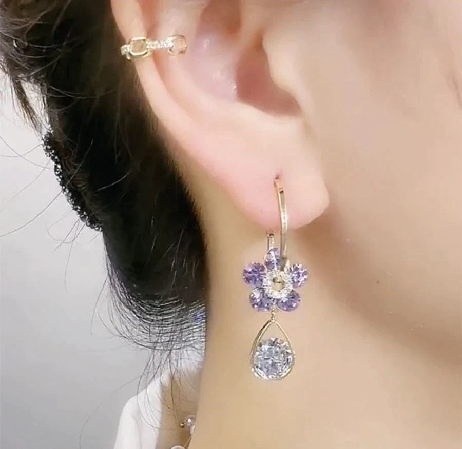 Boucles d'oreilles pendantes femme avec motif floral en cristal, nuances bleu et violet.