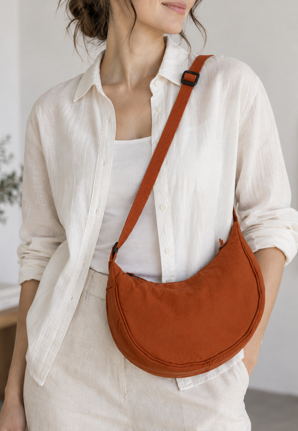 Petit sac femme en nylon noir, forme demi-lune, style décontracté chic avec sangle ajustable.