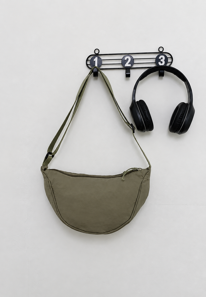 Gros plan sur la texture du sac bandoulière nylon demi-lune pour femme, avec sa sangle ajustable.
