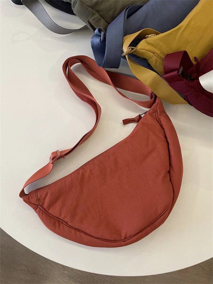 Sac femme bandoulière, vue de face. Forme arrondie élégante, détails soignés, parfait pour le quotidien.