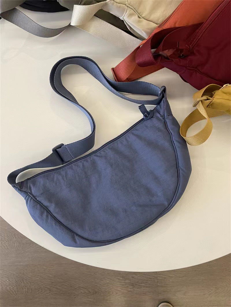 Accessoire de mode femme : sac bandoulière arrondi, style élégant. Complète une tenue sophistiquée.