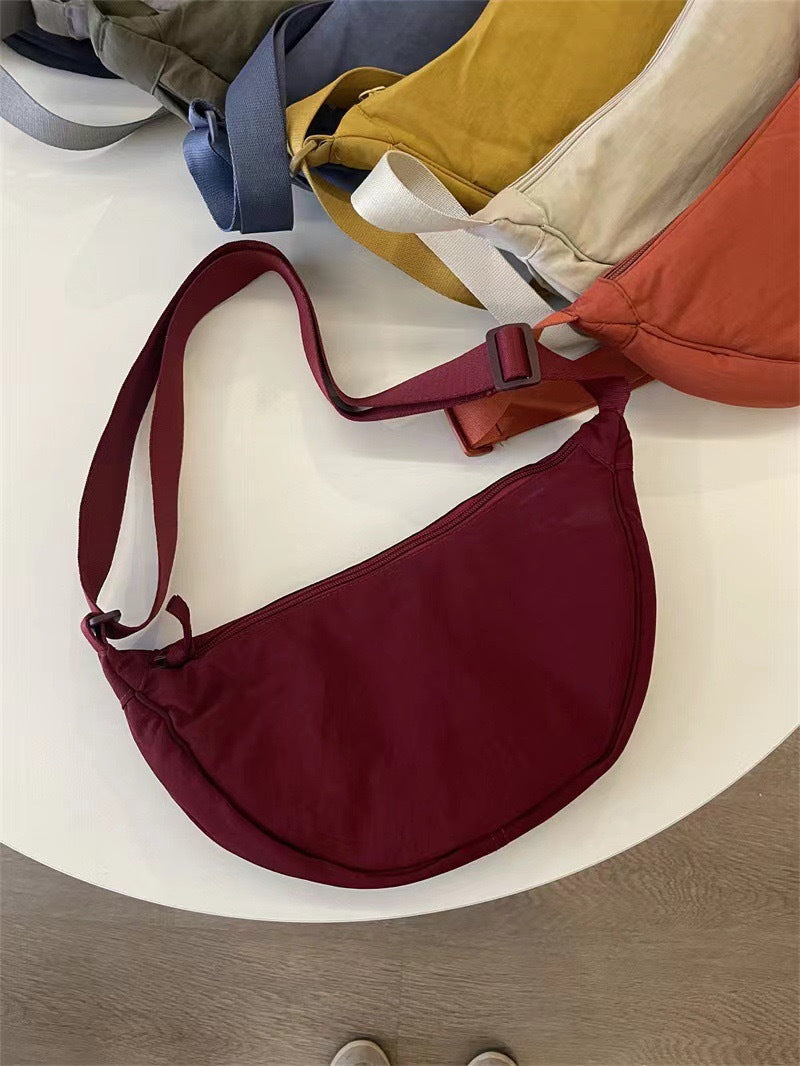 Sac bandoulière femme ajustable, forme arrondie. Essentiel de la mode pour un look chic et pratique.