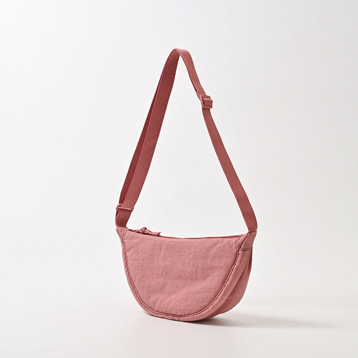 Accessoire femme : sac bandoulière élégant, forme arrondie. Compact et facile à porter, parfait pour la ville.
