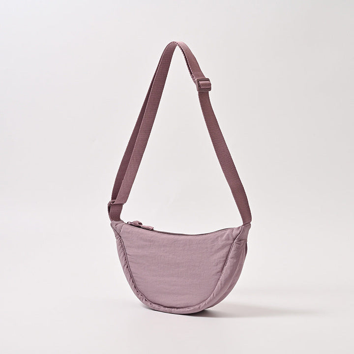 Sac à main femme porté épaule, bandoulière ajustable. Design arrondi, parfait pour la mode féminine contemporaine.