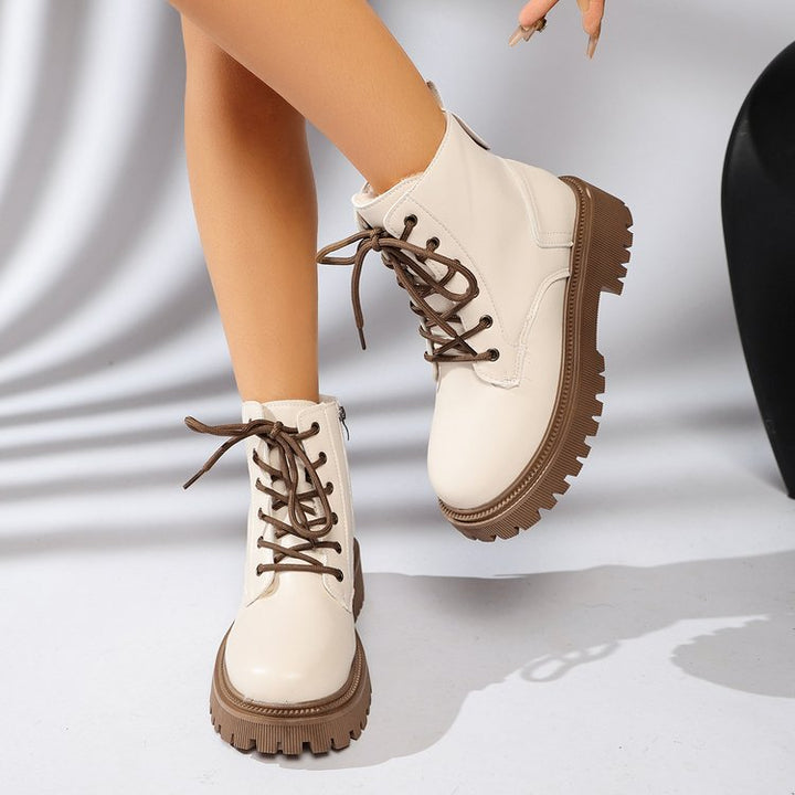 Vue latérale de bottines femme beiges à lacets, semelle track crantée et fermeture éclair. Chaussures d'automne robustes.