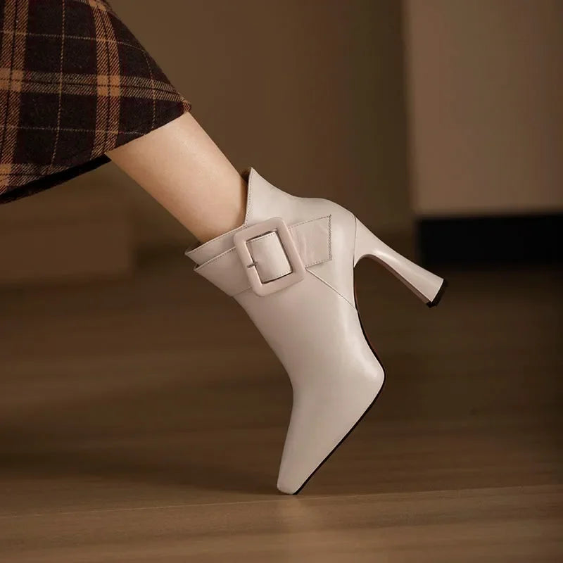 Chaussures femmes : bottines noires à bout pointu, talon et boucle latérale. Style chic pour automne-hiver.
