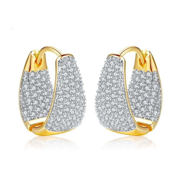 Femme portant des boucles d'oreilles créoles scintillantes, un accessoire mode élégant et intemporel.