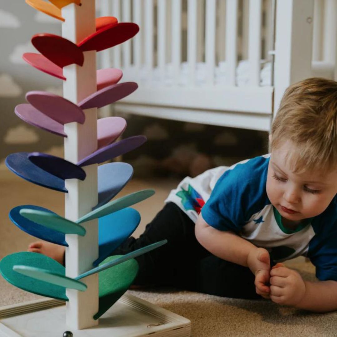 Gros plan sur l'Arbre à Sons Arc-en-ciel Luca, billes colorées descendant pour un son mélodieux, jouet d'éveil.