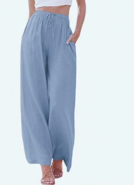 Femme profitant de l'été avec un pantalon large taille haute en lin, look décontracté parfait pour vacances.