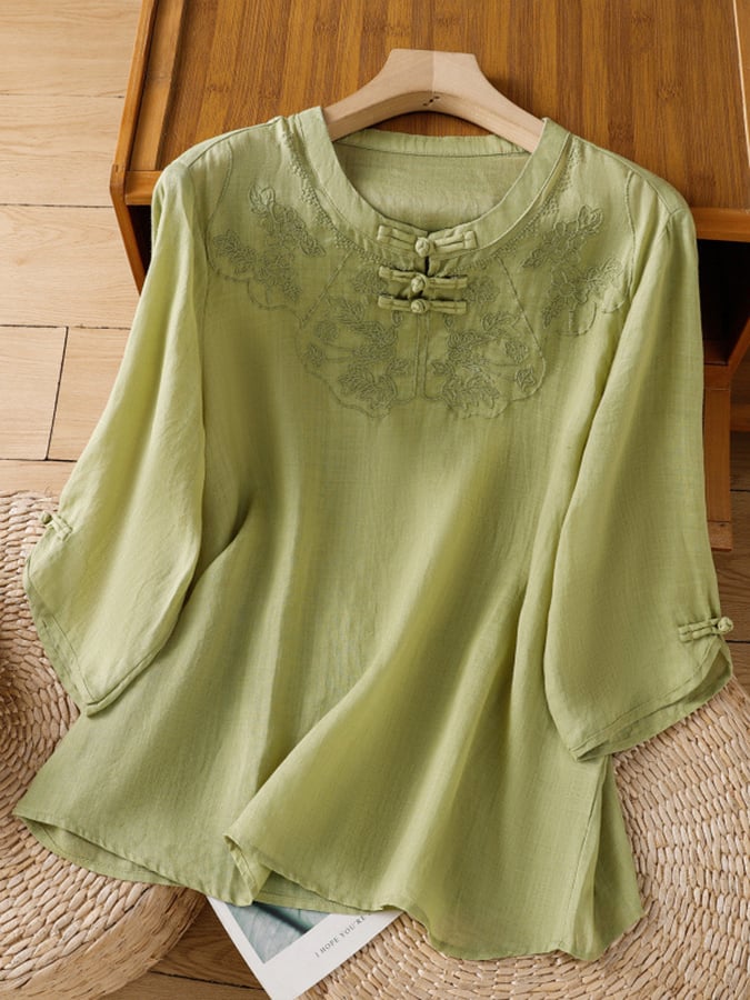 Top femme décontracté à broderies florales délicates, col rond et manches 3/4. Idéal mode féminine printanière.