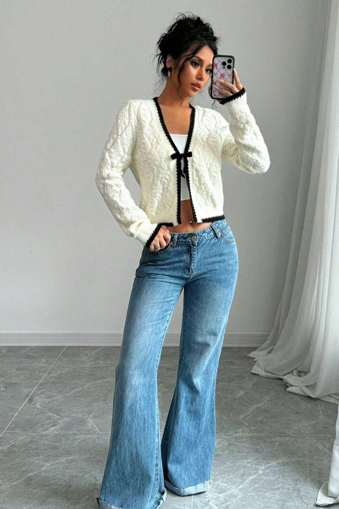 Élégant cardigan ajouré blanc femme à col V, nœud décoratif et manches longues. Style léger et mode.