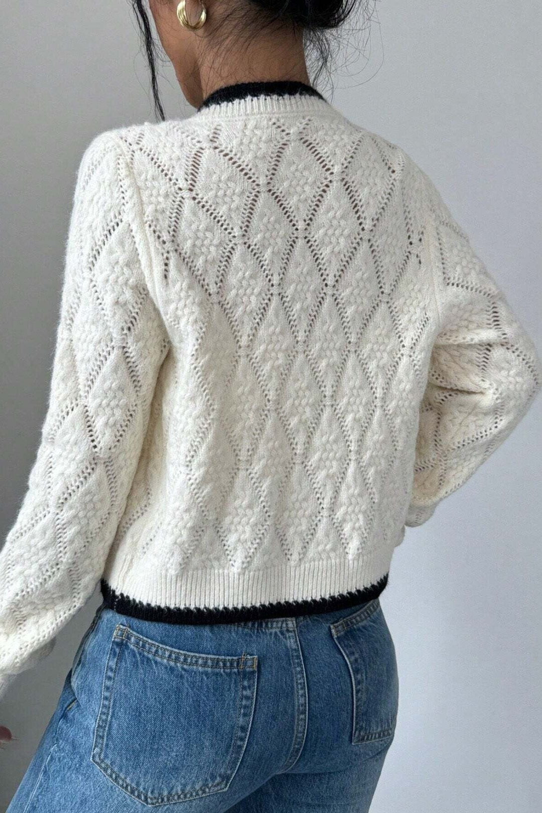Cardigan court blanc ajouré femme, avec nœud et détails contrastés. Parfait pour printemps, automne, mode élégante.